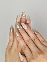 Naillover Golden Brown Floral Shine handmade press on nails styled on hand with matte and shimmering gold tones.